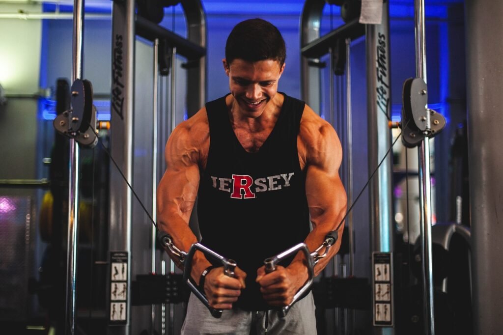 A man performing cable rows at the gym, sitting on a bench and pulling the cable handle toward his torso while keeping his back straight.